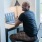 Man sitting at a desk on his computer 