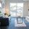 Spacious and well lit living room with carpeted floors and an open floor plan with access to the kitchen.